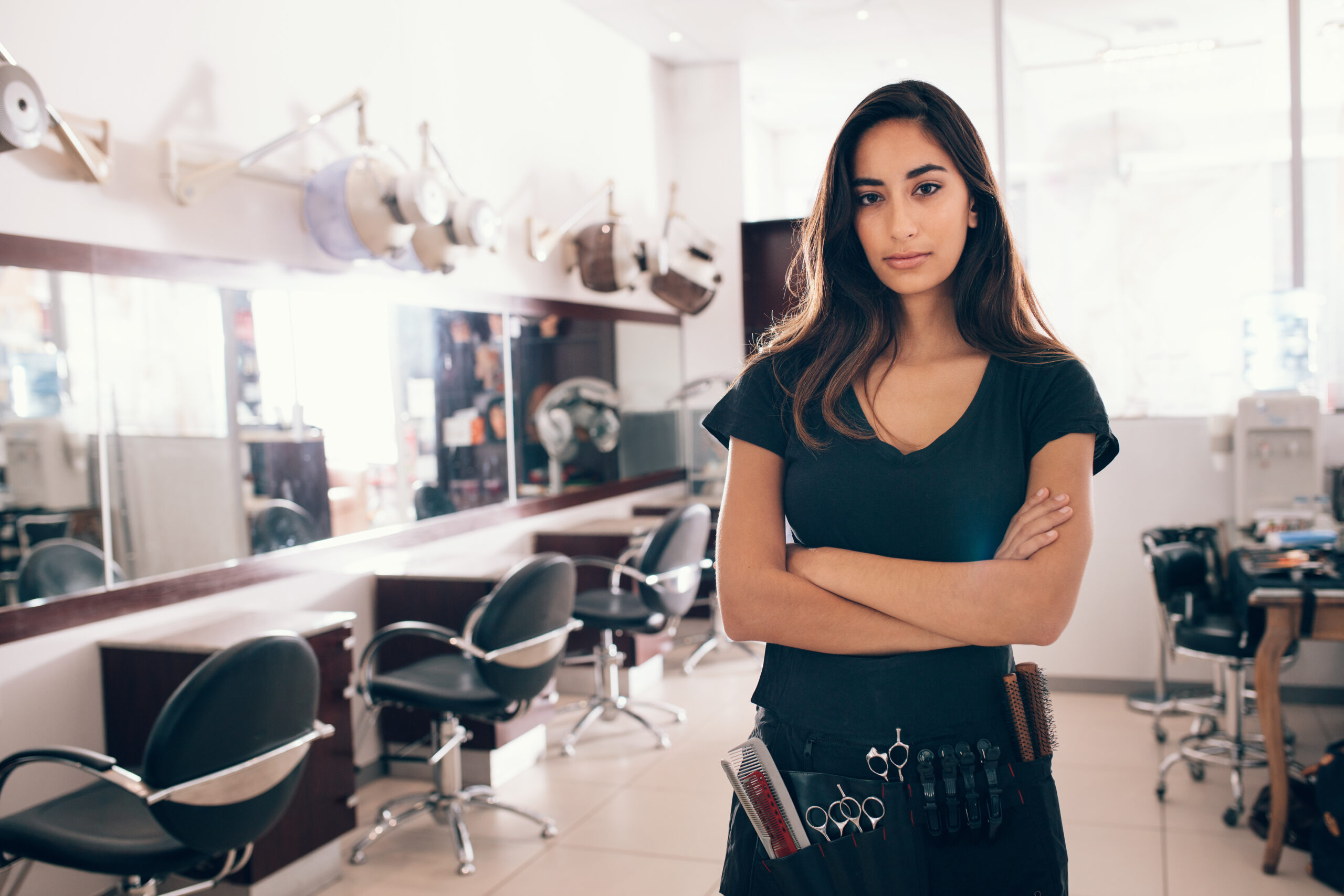 Woman,Standing,With,Hands,Folded,In,Her,Salon.,Professional,Hairdresser